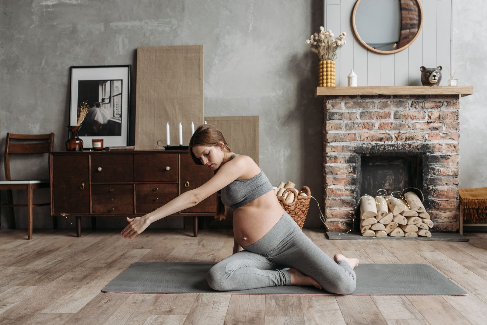 Pregnant woman doing a gentle prenatal yoga stretch on a mat at home